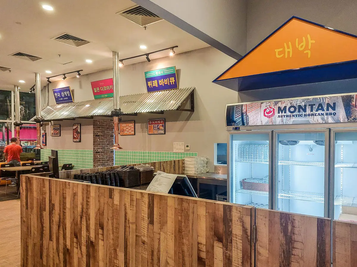 Service counter in timber with overhead signage and display fridges