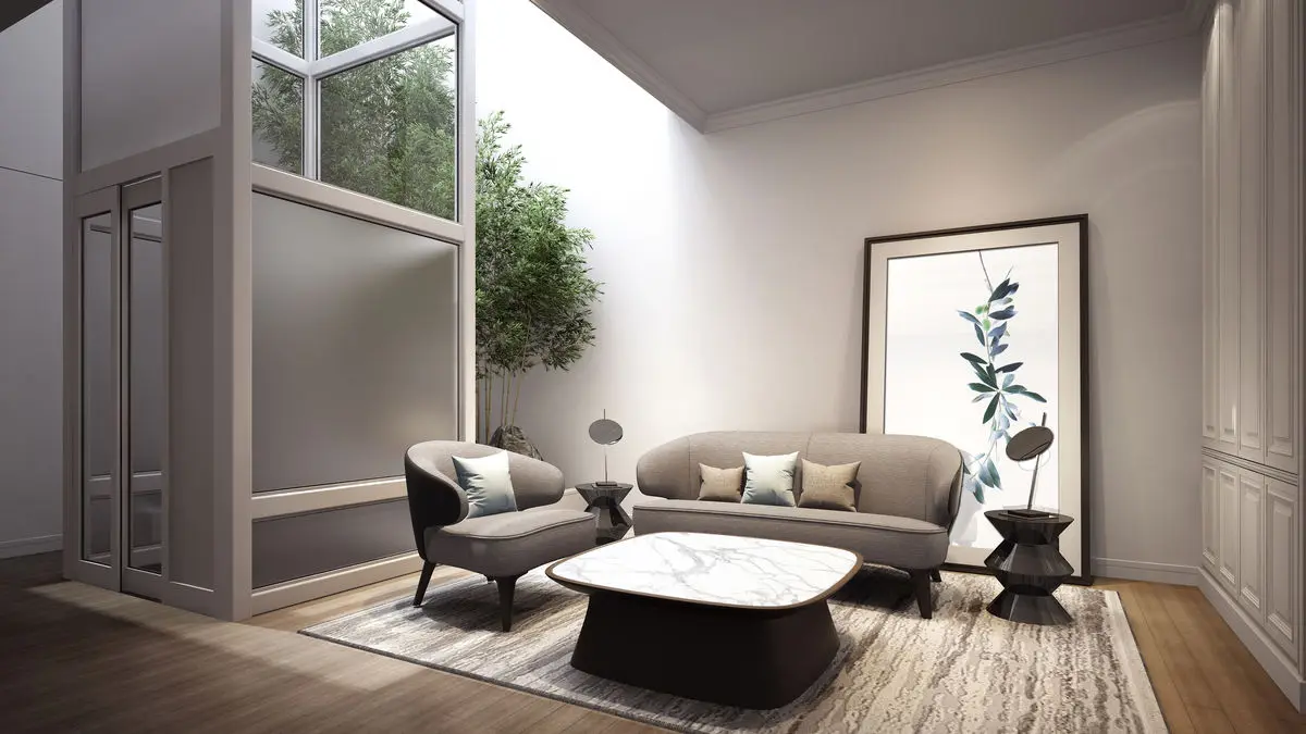 Double-height living space with tall glazing, a low sofa and framed artwork