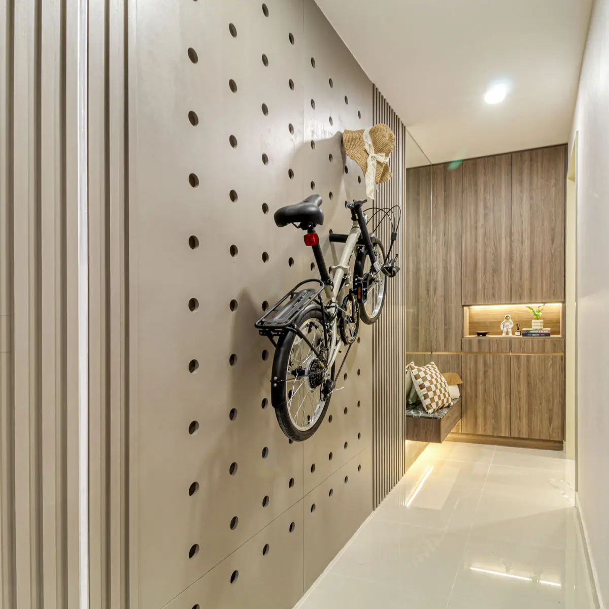 Corridor with a perforated pegboard wall holding a folding bicycle