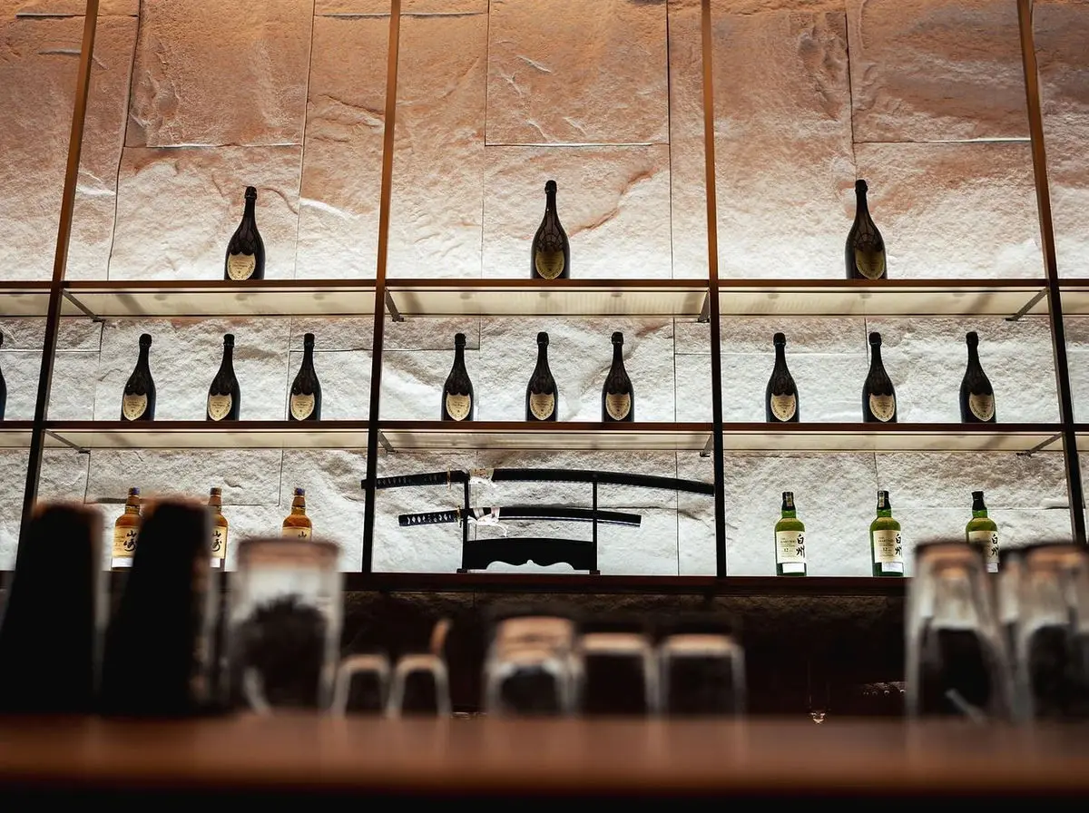 Backbar shelving in stone with champagne bottles and a katana display