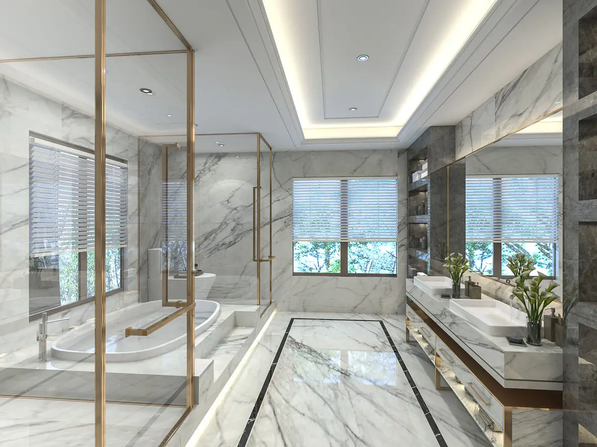 Marble bathroom with a glass shower enclosure, freestanding tub and brass-framed screen