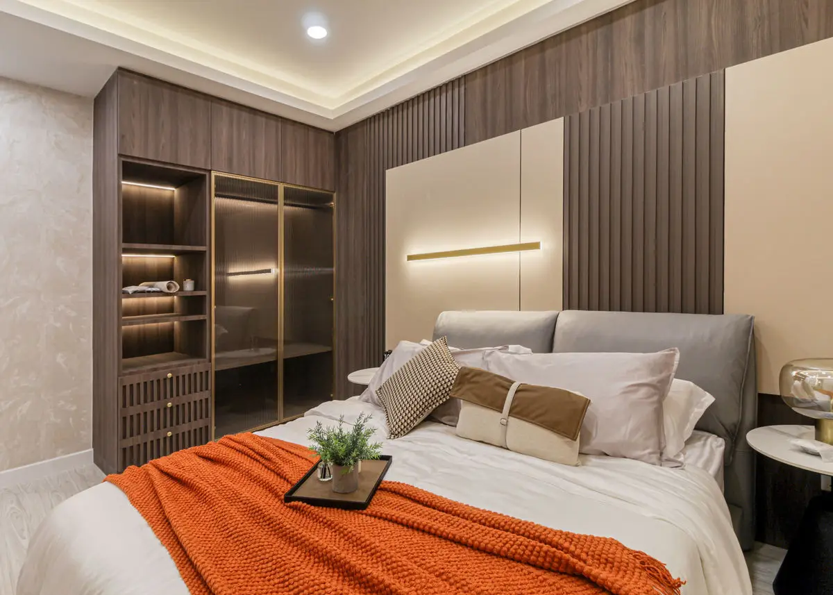 Bedroom with a timber slat headboard wall, backlit wardrobe and an orange throw