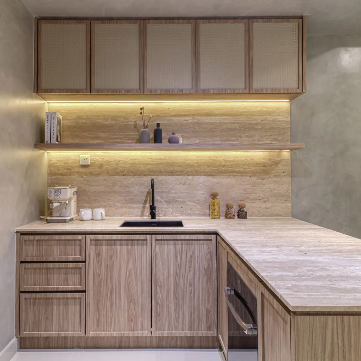 Kitchen corner with a black sink, travertine backsplash and backlit open shelf