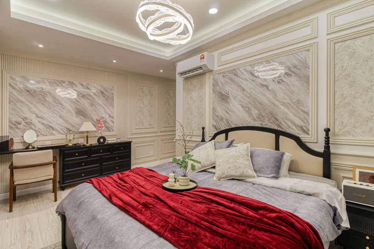 Bedroom with a carved dark timber bed, marble feature wall and a circular pendant light