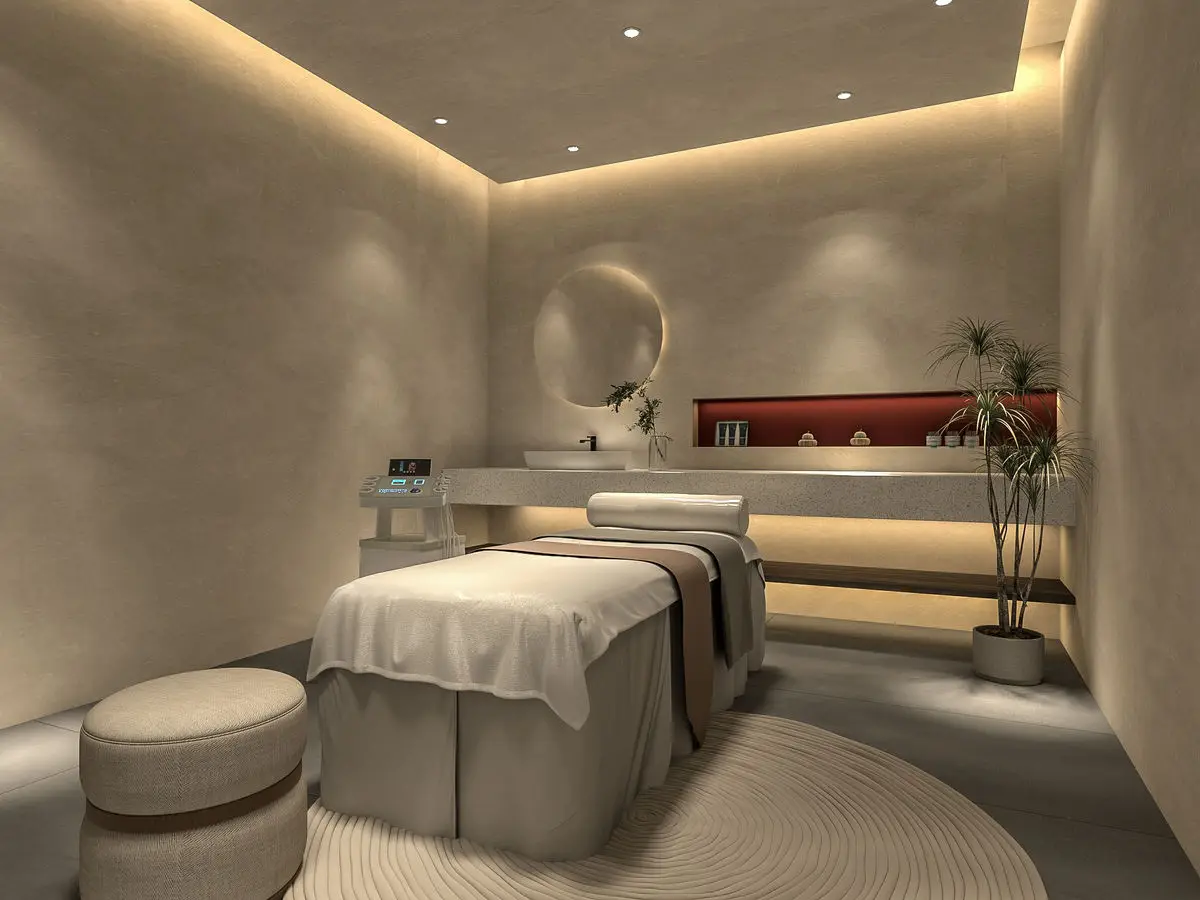 Treatment room with micro-cement walls, a massage bed and a round mirror