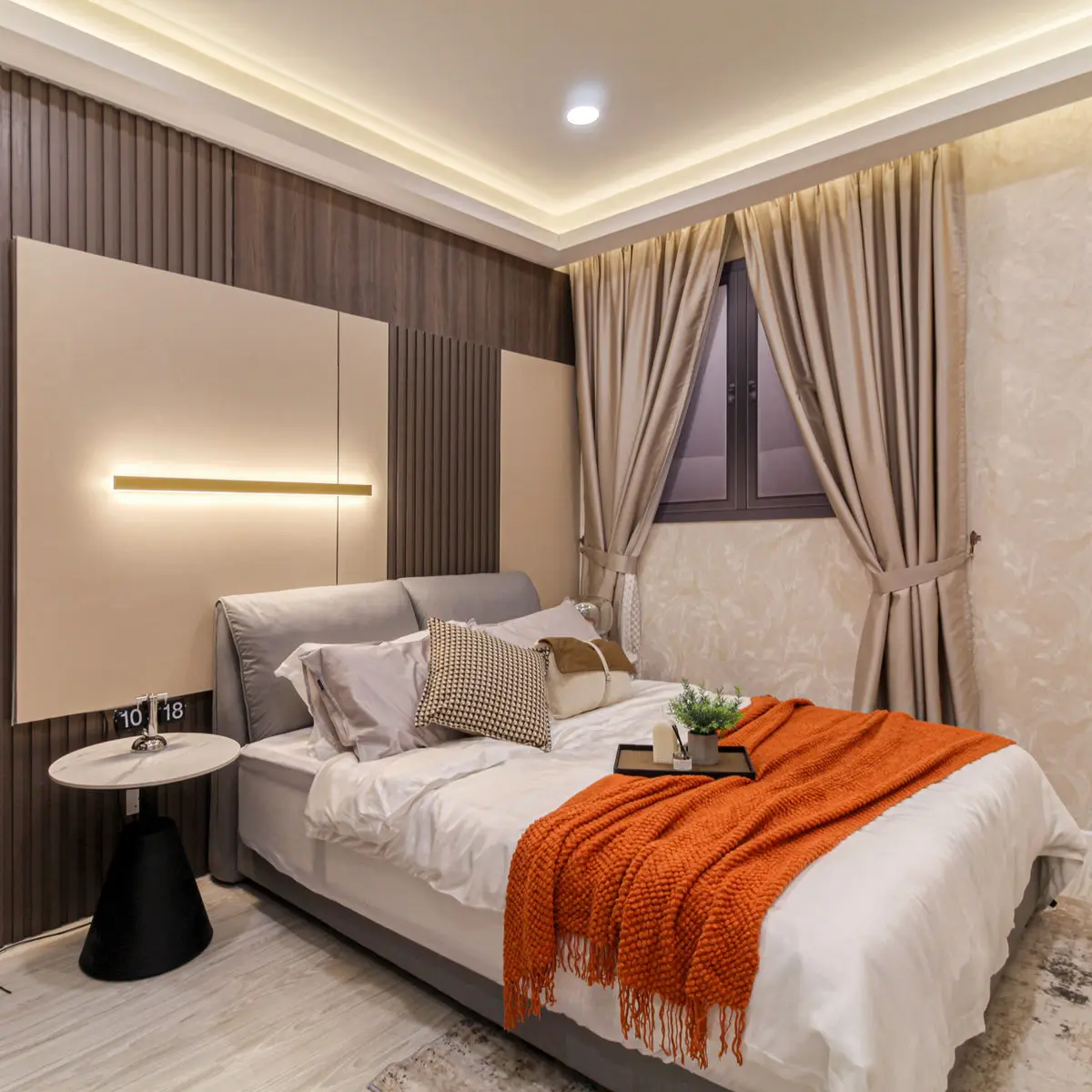 Bedroom with a fluted timber wall, linear wall light and curtained window
