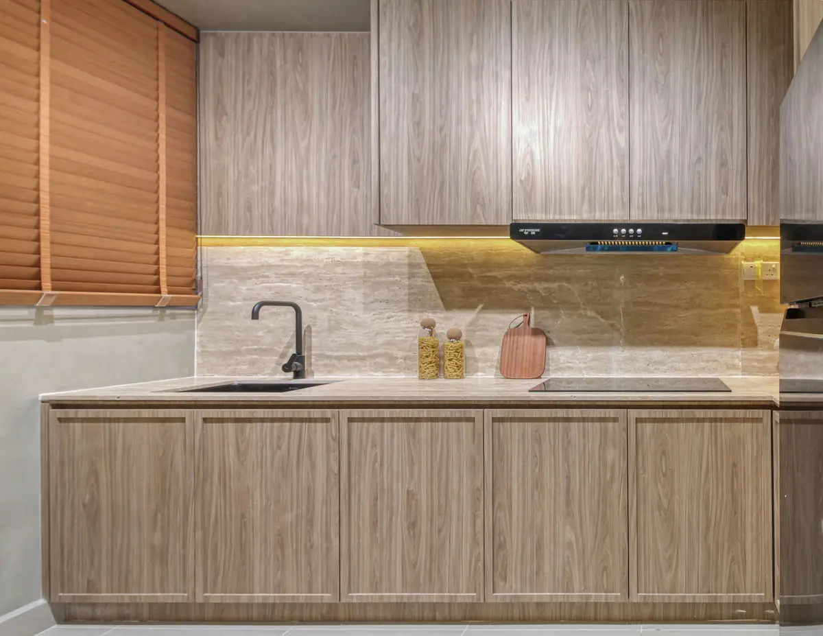 Kitchen run with pale timber cabinets, induction hob and a slim extractor hood