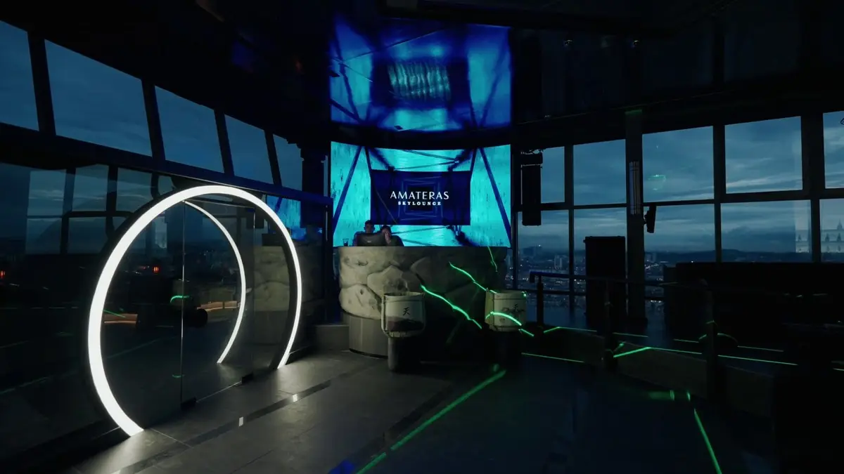 Interior at night with a lit ring, blue LED screen and the skyline through the glass
