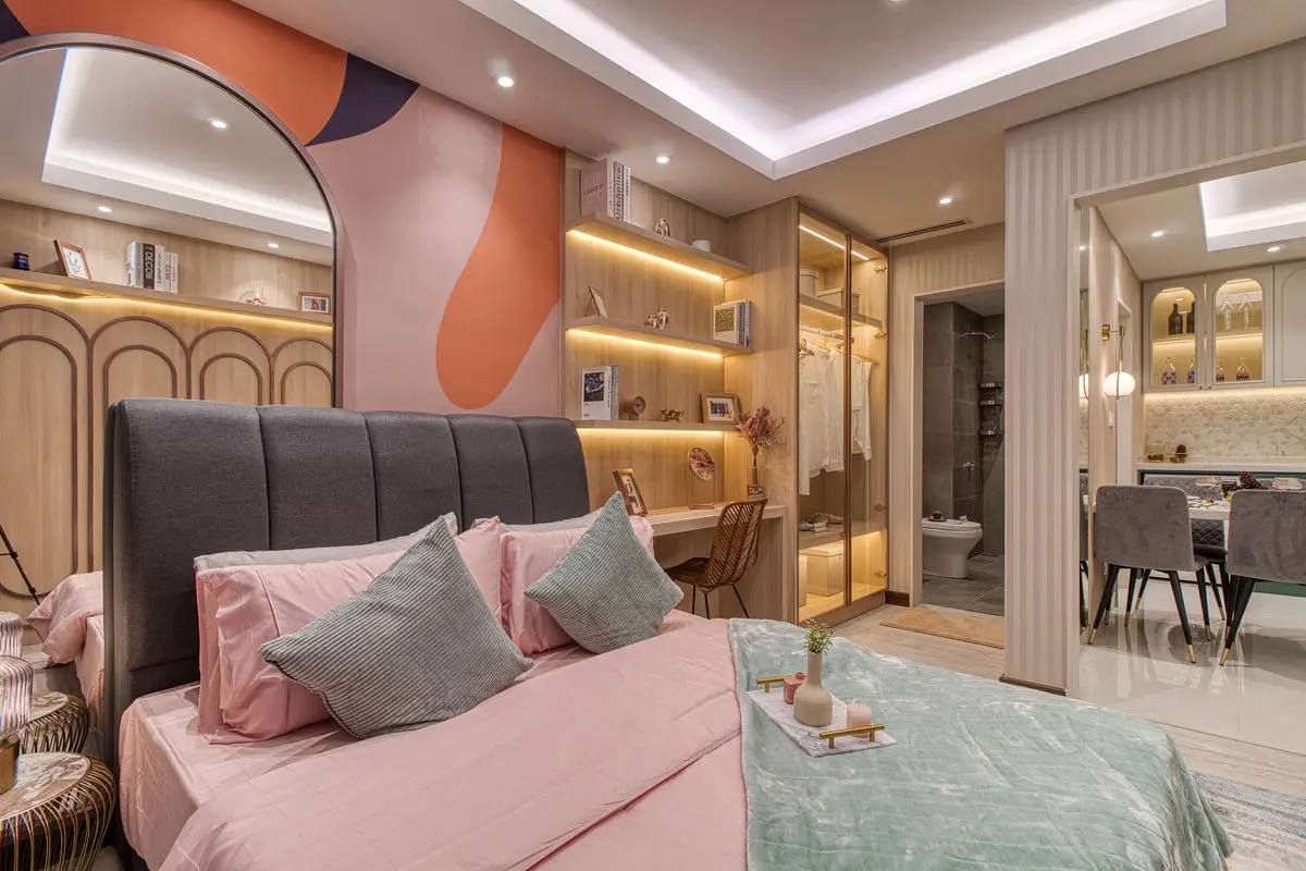 Bedroom with a painted mural wall, pink bedding and a mirrored dressing area