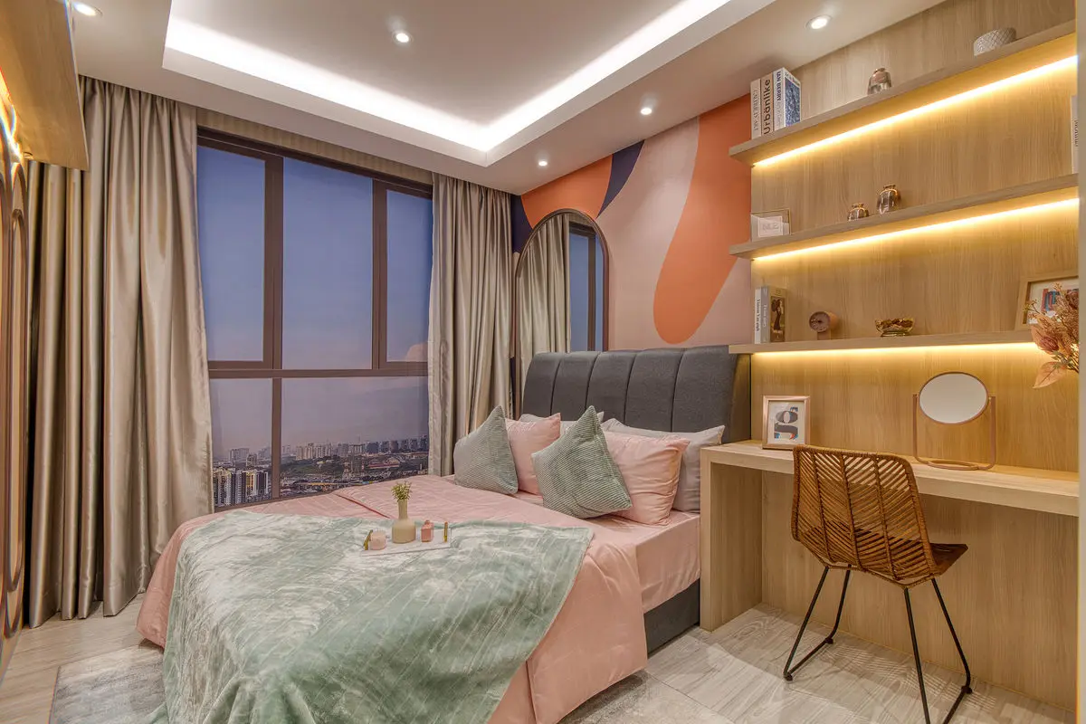 Bedroom with a grey upholstered bed, built-in desk and city view