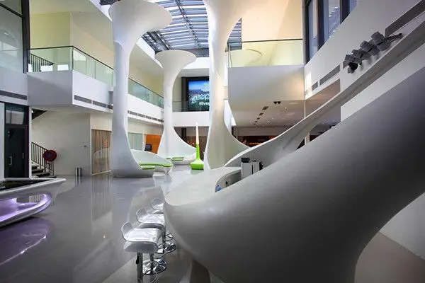 Gallery walkway with curved white balustrades and a wall screen