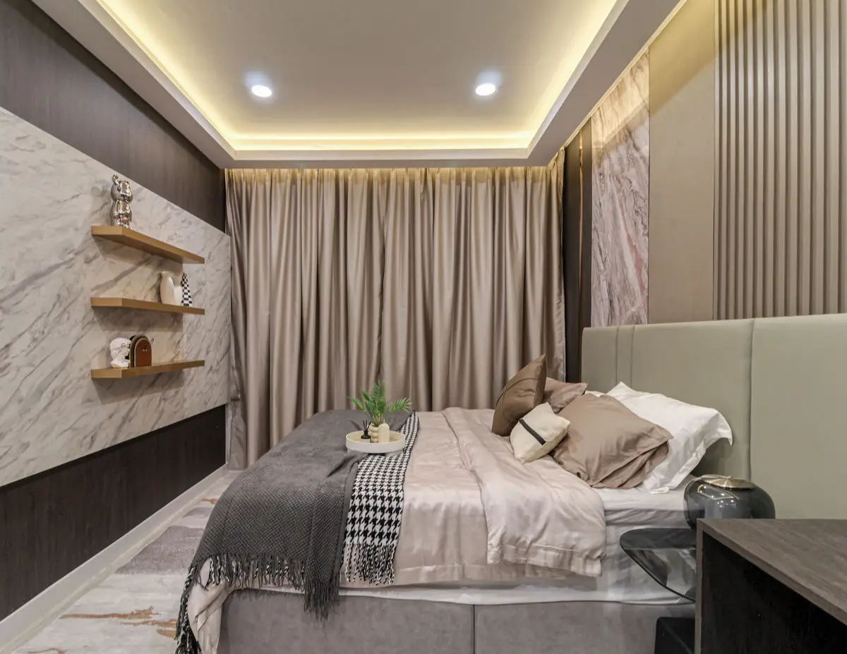 Bedroom with a stone feature wall, floating timber shelves and layered bedding