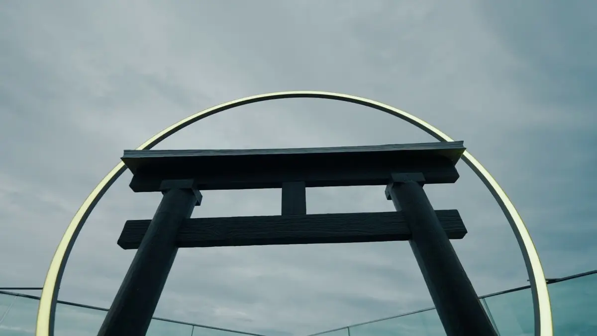 Torii gate framed by an illuminated ring against the sky