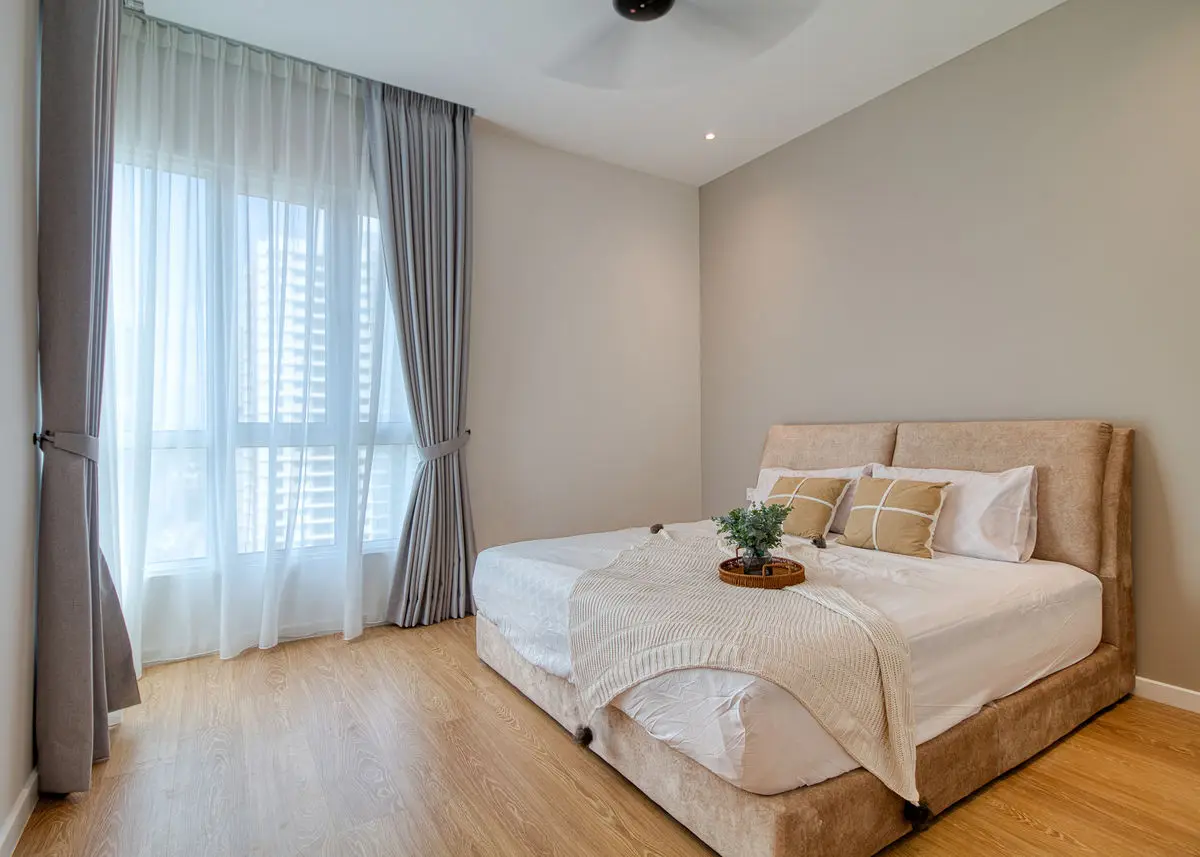 Bedroom with sheer and blackout curtains, upholstered bed and wood floor
