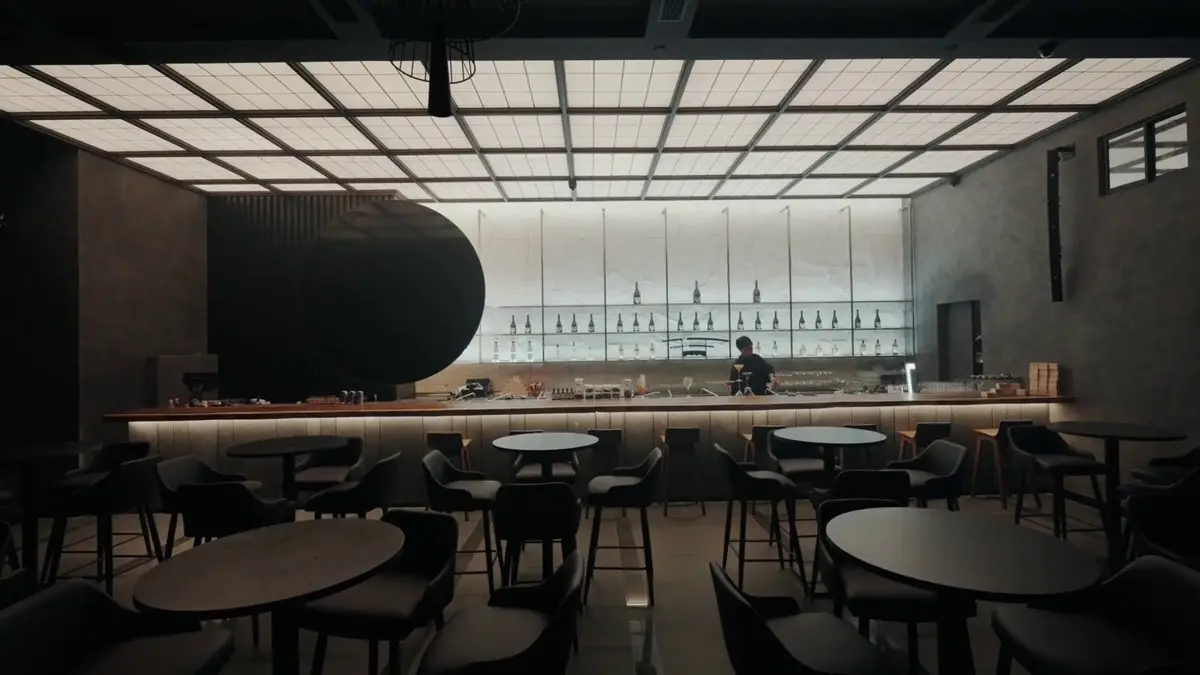 Bar with a black disc feature, grid ceiling and round tables