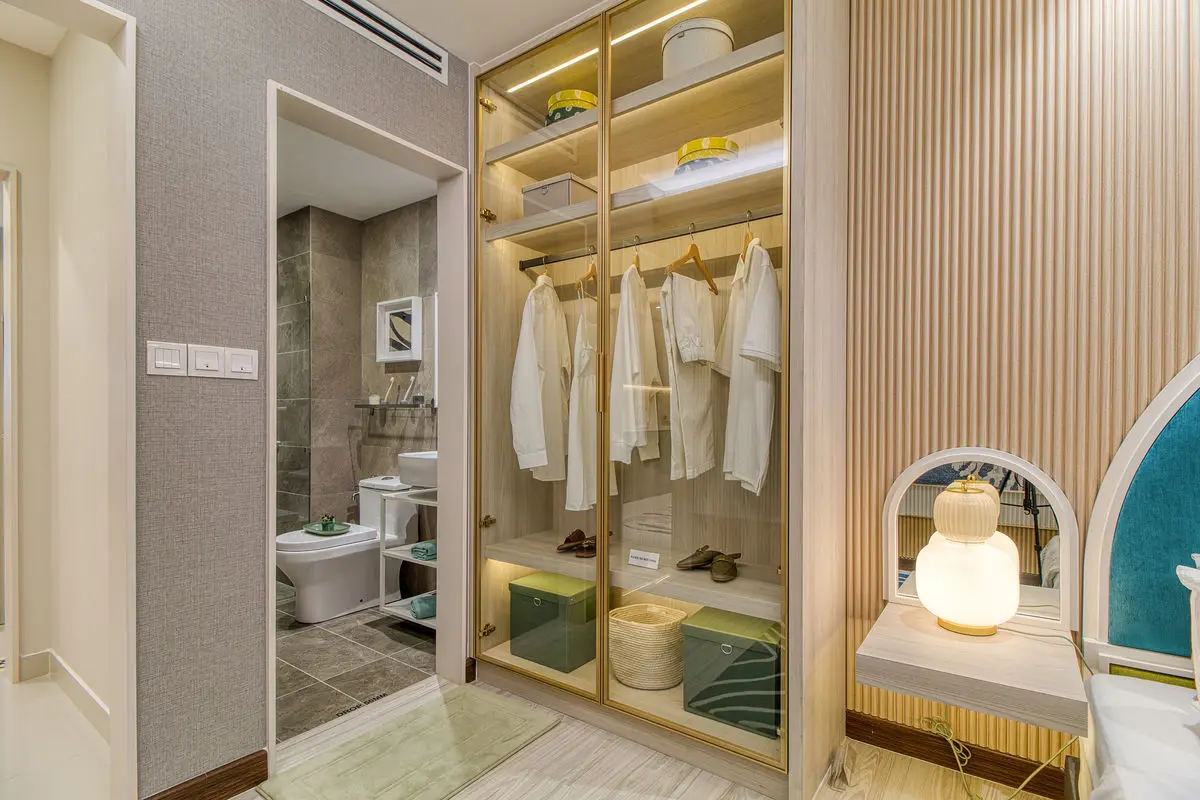 Walk-in wardrobe with brass-framed glass doors, beside the ensuite bathroom