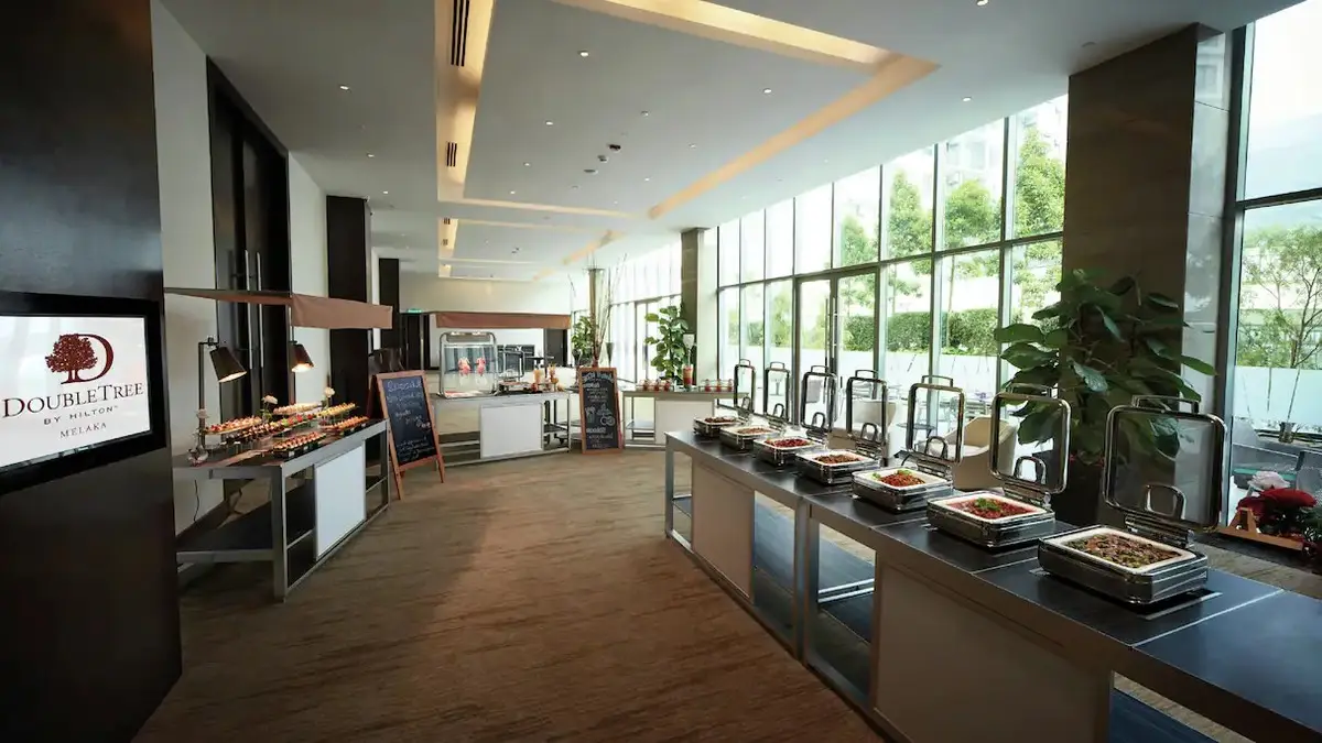 Hotel breakfast buffet counter beside full-height windows