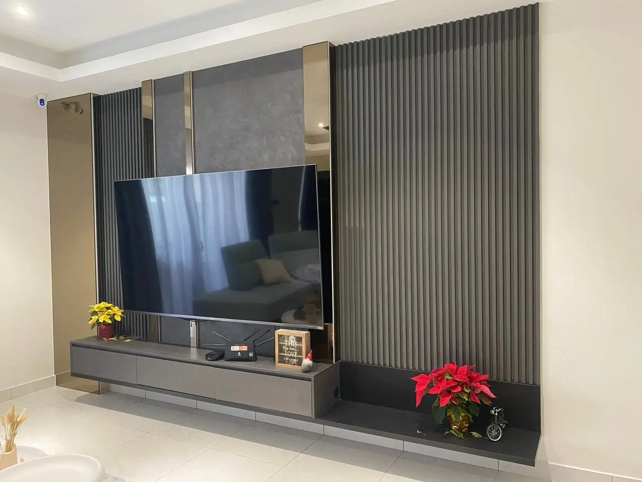 Completed TV feature wall in grey fluted panelling, bronze mirror strips and floating media console