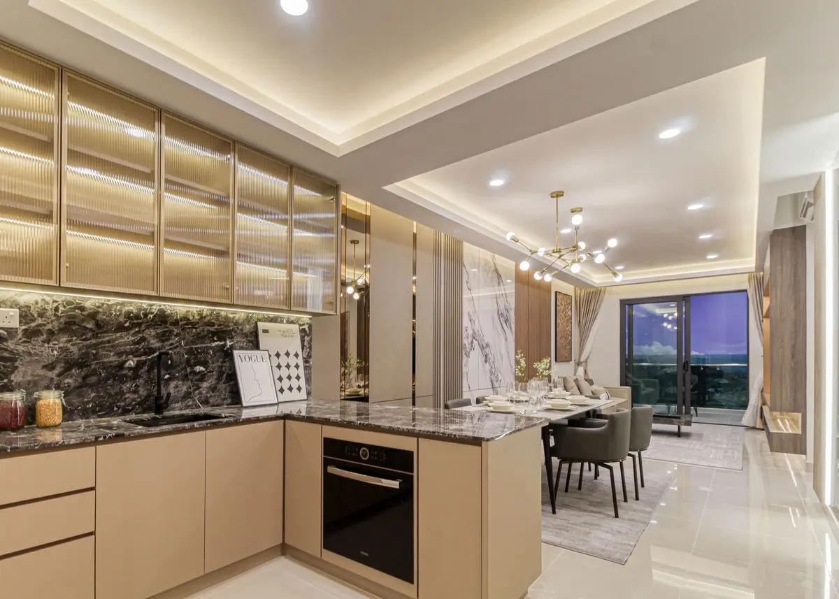 Kitchen with cream cabinetry and a stone backsplash, opening to the dining area