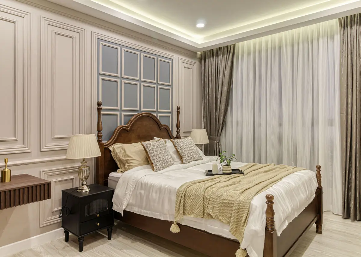 Bedroom with a carved headboard, panelled wall and cove lighting