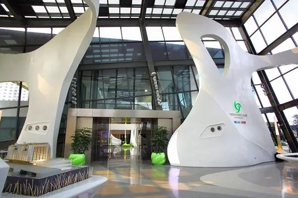 Entrance flanked by two large sculptural forms with brand signage