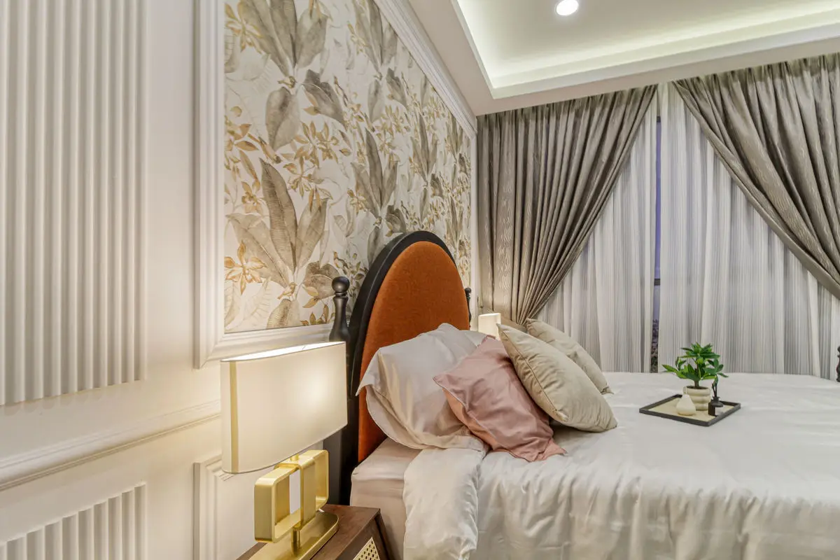 Bedroom with an arched upholstered headboard, botanical wallpaper and brass bedside lamps