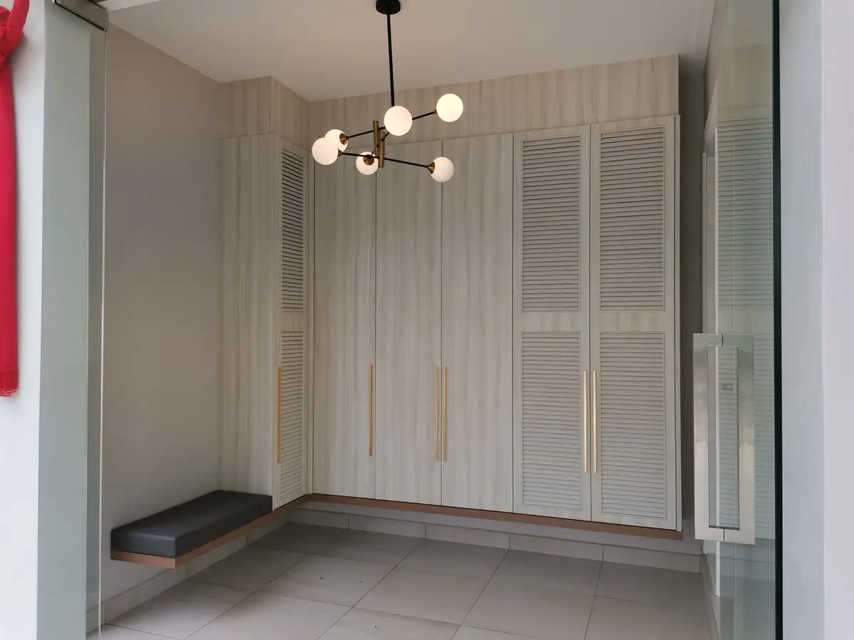 Utility area with louvred wardrobe doors, a bench seat and a sputnik pendant light