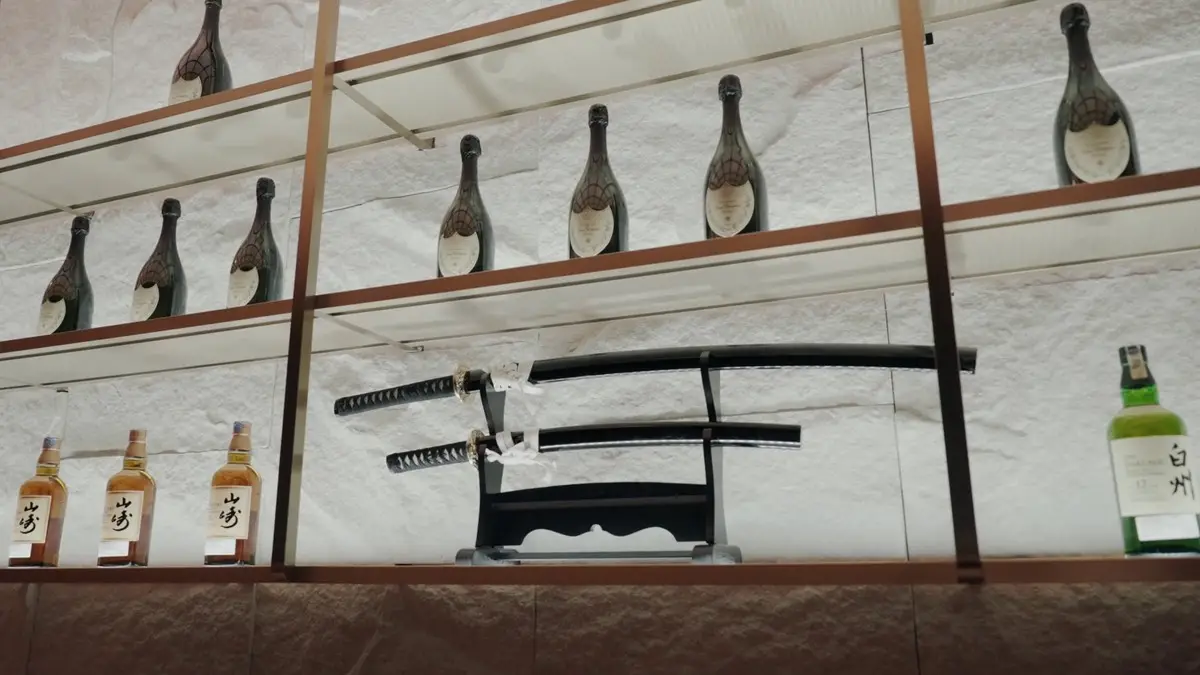 Backbar display with champagne bottles, katana blades and stone shelving