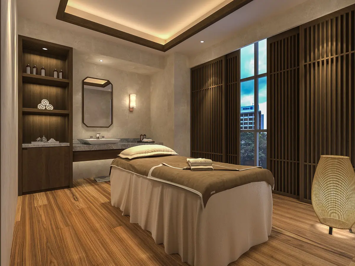 Treatment room with a massage bed, backlit shelving and a city view