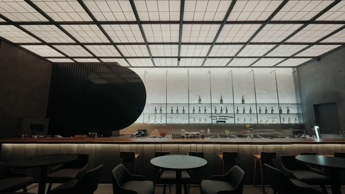 Bar and dining room with a black disc feature and grid-lit ceiling