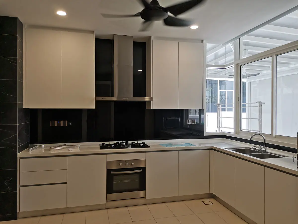 Kitchen with pale handleless cabinets, black backsplash, built-in oven and hob, and windows along the counter