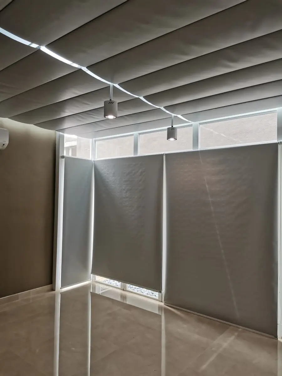 Room with fabric-panelled wall linings and surface-mounted track lighting