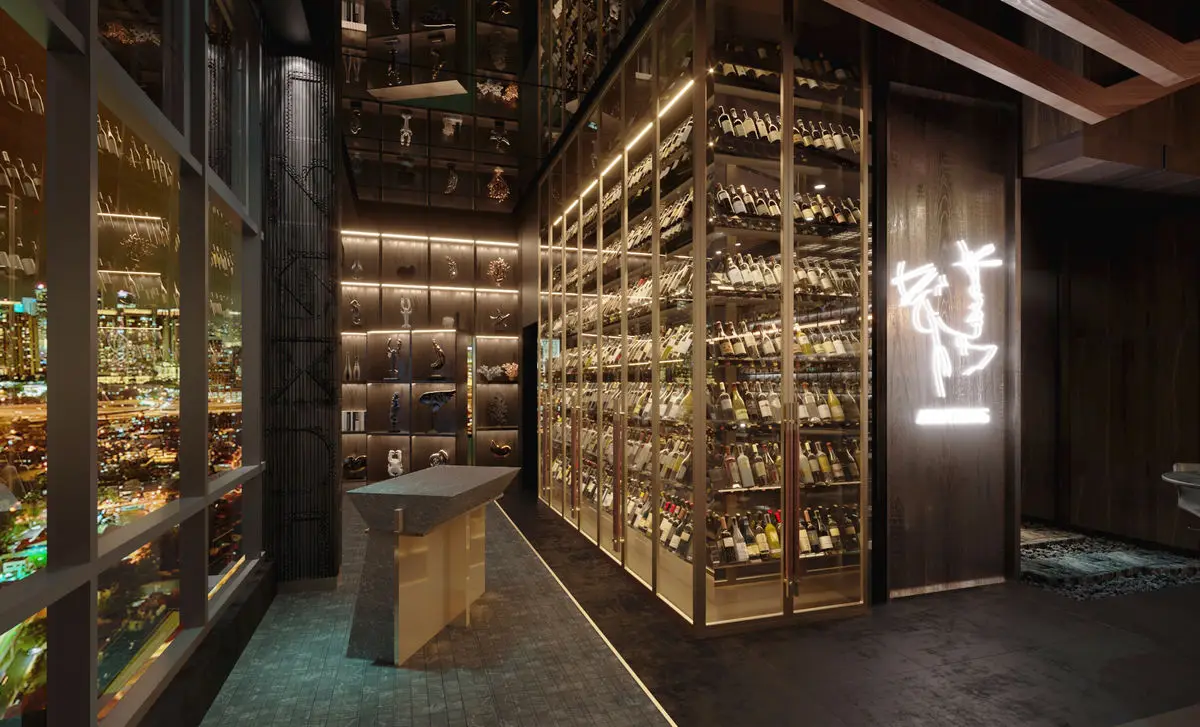 Bottle display walls flanking a walkway, with neon signage and city views